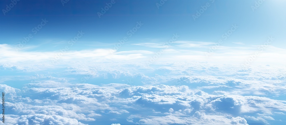 Poster aerial view of an airplane flying in a sky with fluffy clouds