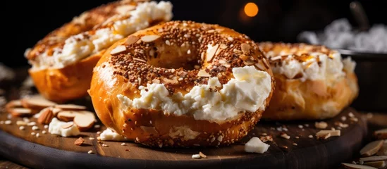 Fotobehang Two bagels with cream cheese and nuts on a wooden board © Ilgun