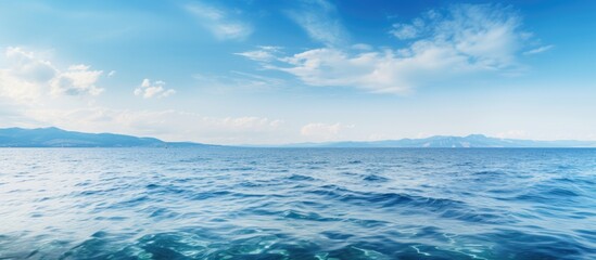 Fototapeta premium Ocean view under clear blue sky and fluffy clouds