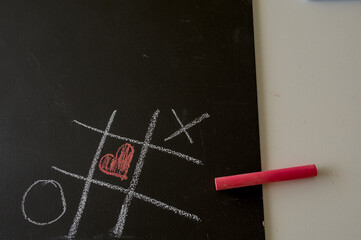 three in a row with heart on a blackboard