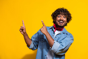 Photo portrait of attractive man point excited empty space dressed stylish denim clothes red scarf isolated on yellow color background