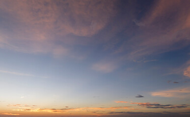 Colorful sunset sky with setting sun behind vivid orange and yellow clouds