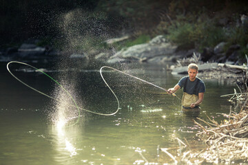 Man roll cast fly fishing on river