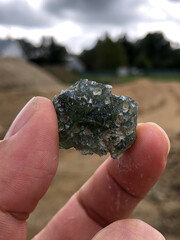 Holding up a freshly mined moldavite gem
