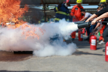 Employees firefighting training, Concept Employees hand using fire extinguisher fighting fire...