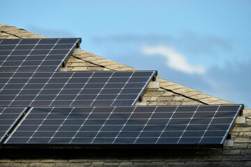 Fototapeta premium Residential house with rooftop covered with solar photovoltaic panels for producing of clean ecological electrical energy in suburban rural area. Concept of autonomous home