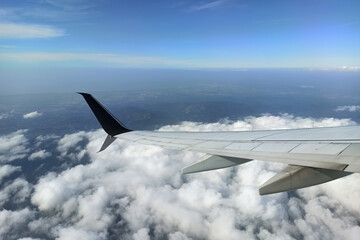 Obraz premium View through airplane window of commercial jet plane wing flying high in the sky. Air travelling concept