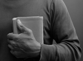 man praying to god with hands together on dark background stock photo	