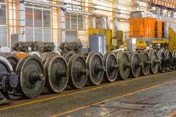 Row of steel wagon train wheels in a repair depot. Wheels of train in service industrial hall.
