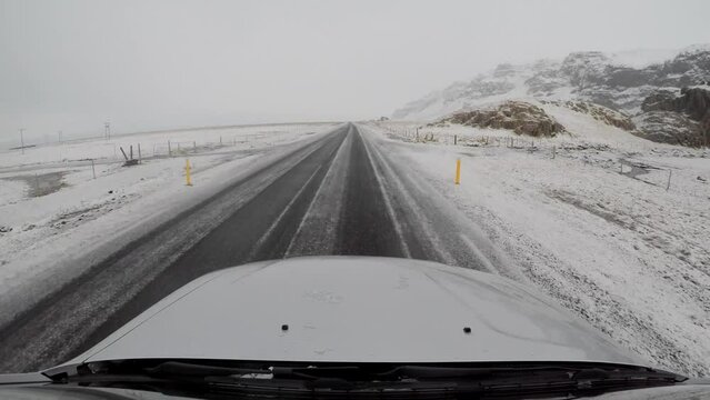 Driving in Iceland across icy countryside and snowy mountains
