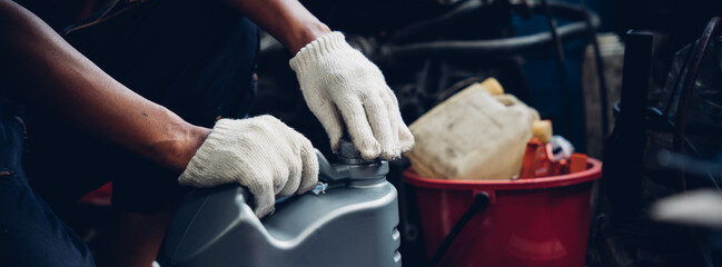 A man is wearing gloves and holding a container with a white cap