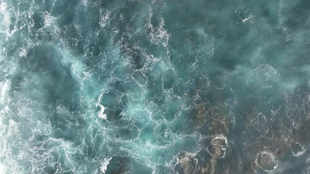 Aerial top view footage of breaking surf with foam in Atlantic ocean. dark ocean waves with white wash.