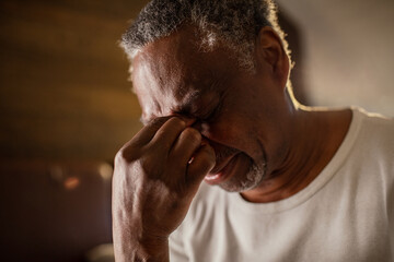 Senior man with a headache at home