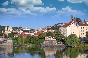 Fototapeta na wymiar View from the bank of the Vltava river to the Prague castle,churches and old town buildings