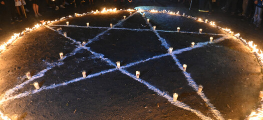 Witchcraft Symbol: Pentagram Drawn in Chalk with Candles. Occult Ritual: Pentagon Glyph Surrounded...