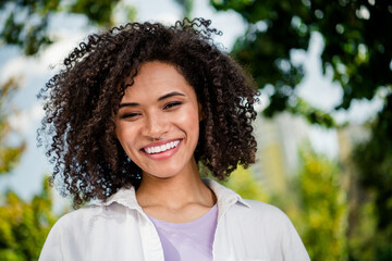 Portrait of cheerful glad adorable young girl smiling spending weekend time walking green forest...