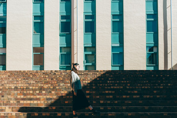 a woman standing on a modern building in the sunlight