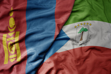 big waving national colorful flag of equatorial guinea and national flag of mongolia.
