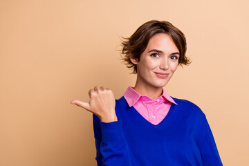 Photo of positive pretty woman wear blue pullover showing thumb empty space isolated beige color...