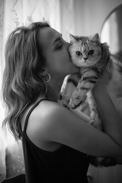 A black and white photo of a girl with a cat.