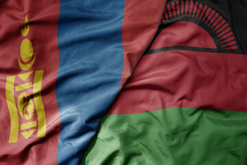 big waving national colorful flag of malawi and national flag of mongolia.