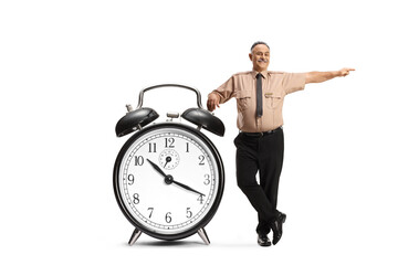 Security officer leaning on a big alarm clock and pointing to the side