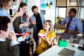 Office birthday celebration with colleagues enjoying cake and champagne
