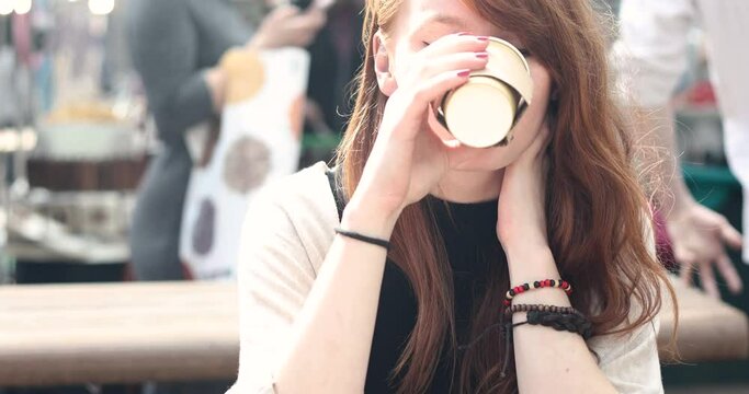Happy young woman drinking a coffee in the city