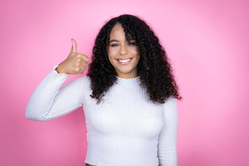African american woman wearing casual sweater over pink background success sign doing positive...