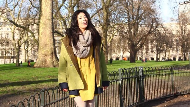 Happy asian young woman enjoying a sunny day at park in London