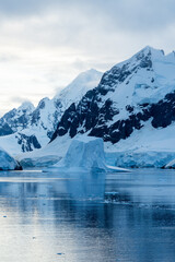 Expedition cruise ship passing through Lemaire channel in Antarctica at sunrise