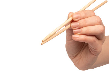 Female hand holding wooden sushi chopsticks isolated on white background.