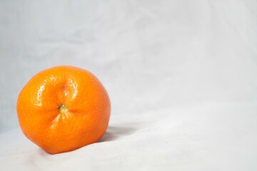 A small orange sits on a white background