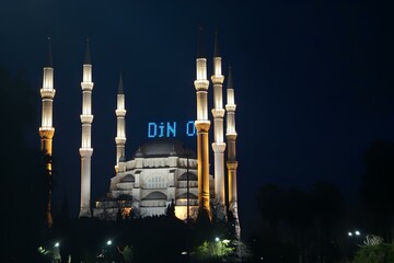 A large white mosque with a blue sign