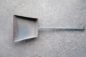 A metal spatula is laying on a grey surface