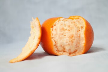A peeled orange with a bite taken out of it