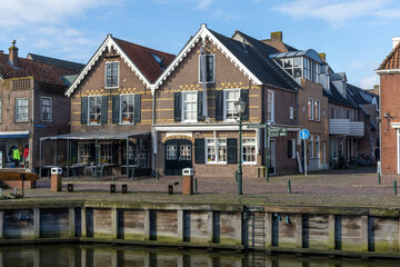 Fototapeta na wymiar Spakenburg, the Netherlands. 25 February 2024. A street with typical houses in Spakenburg next to the waterfront. The village has several harbors