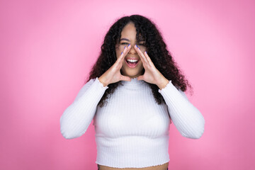 African american woman wearing casual sweater over pink background shouting and screaming loud to...