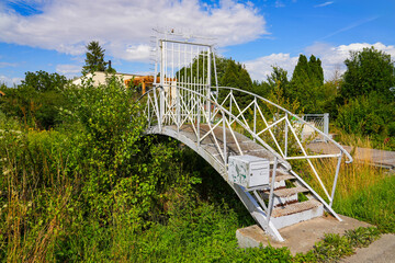 Small footbridge spanning a swampy canal in the Hortillonnages of Amiens to access a country house...