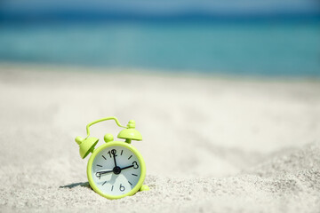 Fototapeta na wymiar beautiful alarm clock in the sand by the sea on nature background