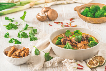 Vegan Tom Kha Gai soup with various vegetables and roasted soy-based meat substitutes