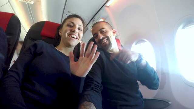 Happy couple on a plane enjoying honeymoon trip together