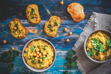 Hummus, chickpea puree in a bowl and on toasted bread slices