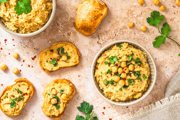 Hummus, chickpea puree in a bowl and on toasted bread slices