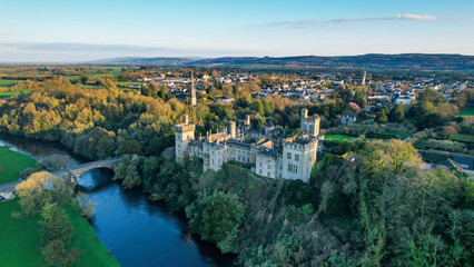 Fototapeta na wymiar Aerial view of majestic Lismore Castle in County Waterford, Ireland, bathed in the golden glow of the setting sun on the first day of spring, showcasing its timeless beauty and historic charm