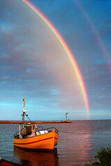 Rainbow over the water, view of the boat and the bay
