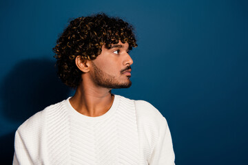 Side profile photo of latin guy in looking empty space demonstrate wavy hair with perfect stubble isolated on dark blue color background