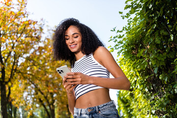 Photo of charming adorable girl blogger wear crop top hold phone read social media summer sunny weather outside
