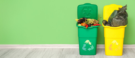 Containers for trash with food waste and full garbage bag near green wall. Recycling concept