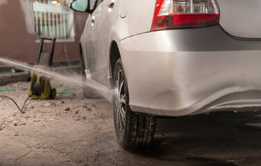 Washing dirty car with pressure washer